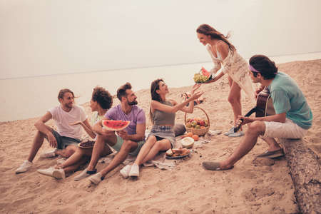 Photo of relaxed positive group buddies picnic gathering share watermelon wear casual outfit nature seaside beach outdoorsの写真素材