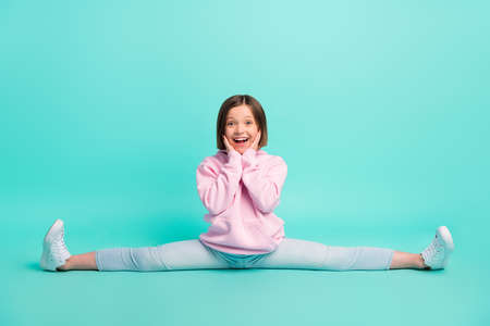 Full size photo of brunette hairdo cute girl sit twine wear pink sportswear isolated on teal color backgroundの写真素材