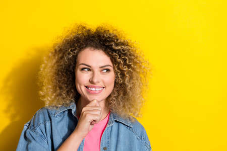 Photo of playful clever pensive lady finger chin look empty space wear jeans jacket isolated yellow...