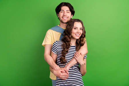 Photo of young lovely couple happy positive smile hug cuddle embrace love isolated over green color...