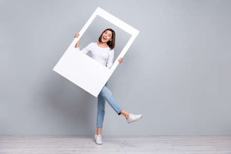 Full body photo of impressed brunette young lady play frame wear shirt jeans sneakers isolated on...