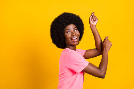 Profile side photo of young african girl happy positive smile have fun enjoy music dancer isolated over yellow color backgroundの写真素材
