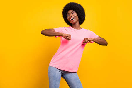 Photo of young cheerful afro girl happy positive smile have fun dance discotheque isolated over yellow color backgroundの写真素材