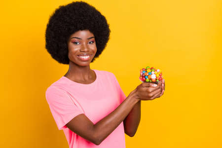 Photo of young cheerful afro girl happy positive smile hold candy dessert tasty diet isolated over...