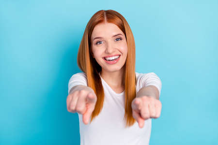 Photo of satisfied candid orange hair lady direct finger you camera toothy smile isolated on blue...