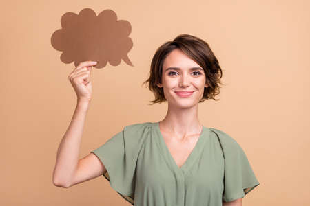 Photo of positive creative lady hold thought bubble wear green dress isolated beige color background