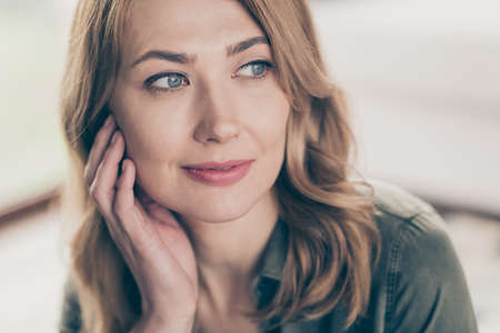 Cropped view portrait of attractive peaceful dreamy wavy-haired woman fantasizing touching face spending time staying at home house flat indoorsの写真素材