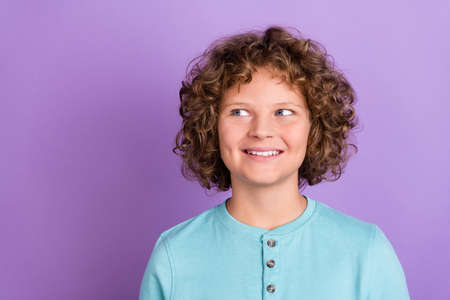 Portrait of attractive cheerful wavy-haired boy overthinking copy space isolated over bright violet purple color backgroundの写真素材