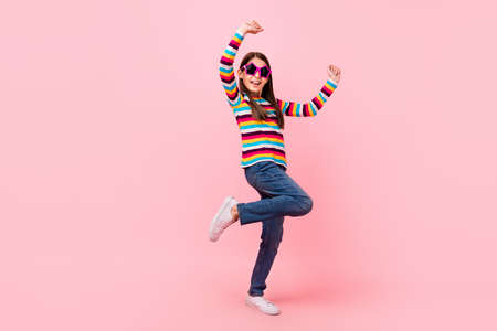 Photo of funky nice small lady dance enjoy crazy party wear star sunglass striped shirt isolated pink color backgroundの写真素材