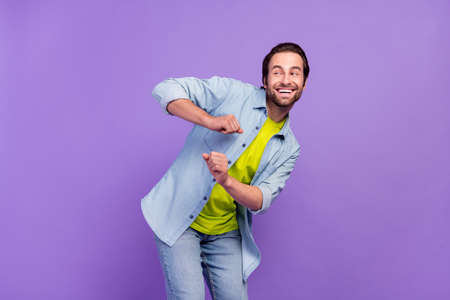 Photo of funky carefree male look copyspace dancing having fun laughing isolated on violet color backgroundの写真素材