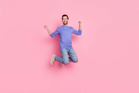 Full size photo of brunet funky millennial guy jump yell wear blue sweater jeans footwear isolated on pink backgroundの写真素材