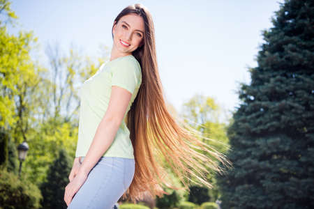 Profile side photo of young attractive pretty woman happy positive smile fly air haircare shampoo outdoorsの写真素材