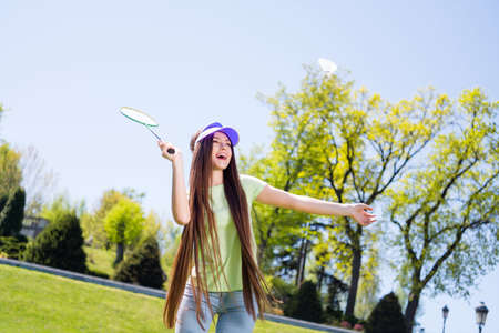 Photo of sweet adorable woman wear green clothes smiling playing badminton outdoors urban city parkの写真素材