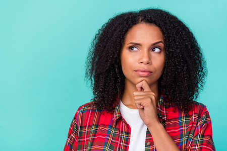 Photo of young attractive african woman hand touch chin guess look empty space minded isolated over...