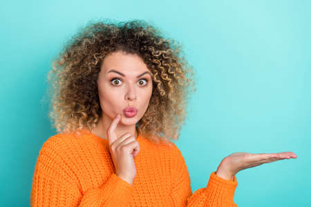 Photo of lovely funky lady palm presenting empty space wear orange knitted sweater isolated teal color backgroundの写真素材