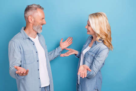 Profile side photo of aged couple happy positive smile speak talk conversation date isolated over blue color backgroundの写真素材