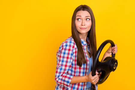 Profile photo of nervous inexperienced driver lady hold steering wheel wear plaid shirt isolated yellow color backgroundの写真素材