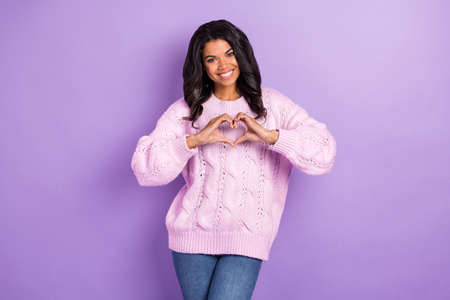 Photo of young african woman happy smile show fingers heart symbol love feelings isolated over purple color backgroundの写真素材