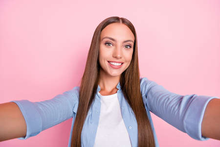 Photo of shiny sweet young woman dressed blue shirt tacking selfie smiling isolated pink color backgroundの写真素材