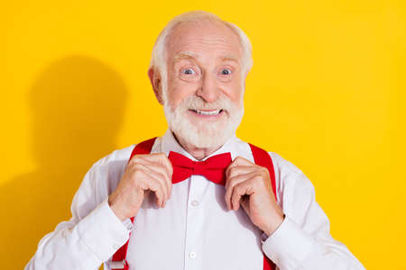 Photo of cool elder man wear tie white shirt red suspenders isolated on yellow color backgroundの写真素材