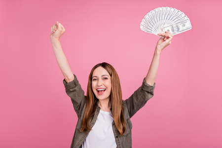 Photo of cheerful lady rejoice victory ecstatic win lottery income dollars cash isolated over pink color backgroundの写真素材