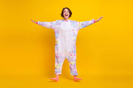 Full length body size photo girl in unicorn costume laughing overjoyed isolated bright yellow color backgroundの写真素材