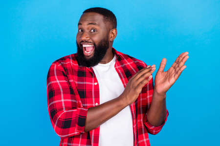 Photo of funky millennial brunet guy clap wear plaid shirt isolated on blue color backgroundの写真素材