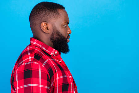 Profile photo of sad young brunet guy wear plaid shirt isolated on blue color backgroundの写真素材