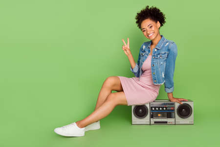 Full size photo of funny millennial lady sit with boom box wear dress shirt sneakers isolated on green backgroundの写真素材