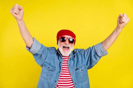 Portrait of attractive cheerful comic grey-haired man rejoicing having fun isolated over vibrant yellow color backgroundの写真素材