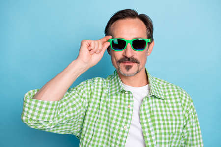 Portrait of attractive content funky man touching specs nice look shopping isolated over bright blue color backgroundの写真素材