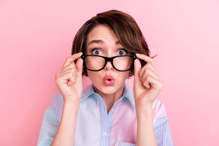 Photo of young woman amazed shocked surprised omg reaction hands touch glasses lens sight isolated over pastel color backgroundの写真素材