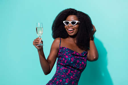 Photo portrait woman with champagne glass laughing in sunglass isolated vibrant turquoise color backgroundの写真素材