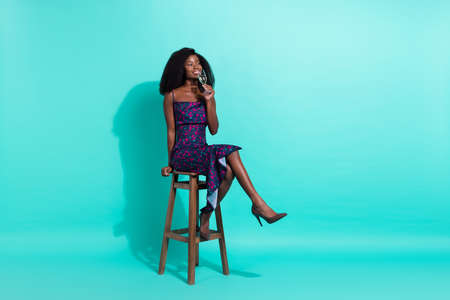 Full size photo of nice optimistic brunette lady sit dink look empty space wear dark dress shoes isolated on teal color backgroundの写真素材