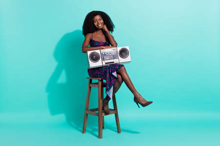 Full size photo of nice optimistic brunette lady sit hold boom box wear dark dress shoes isolated on teal color backgroundの写真素材