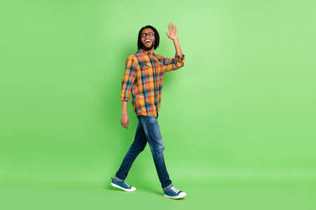 Photo of charming cute dark skin man wear shirt spectacles walking waving arm looking empty space...