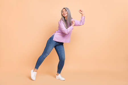 Full size photo of cool white hairdo aged lady dance look promo wear violet shirt jeans sneakers...