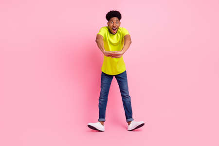 Full length photo of young excited afro guy happy positive smile have fun isolated over pink color backgroundの写真素材