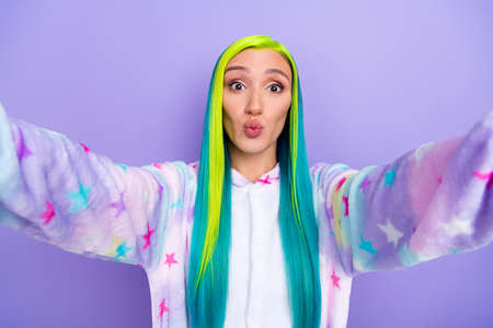 Photo of affectionate lady hold camera take selfie blow air kiss wear kigurumi costume isolated violet color backgroundの写真素材