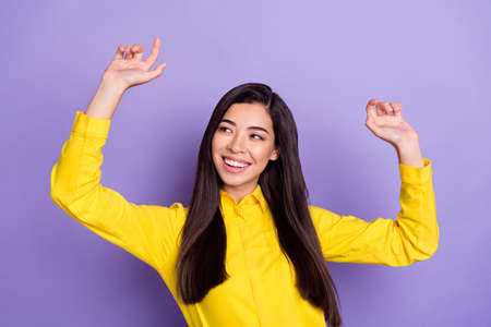 Photo of young woman raise hands good mood dance enjoy free time isolated on purple violet color backgroundの写真素材