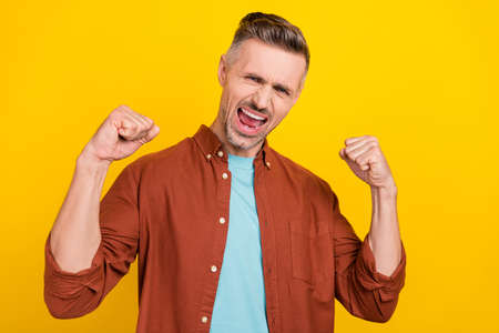 Photo of hooray mature grey hairdo man hands fists wear garment isolated on vivid yellow color backgroundの写真素材