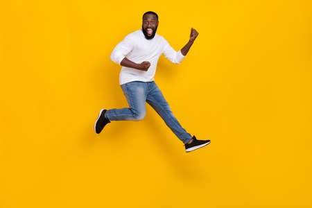 Full length photo of overjoyed person raise fists triumph luck shout yes isolated on yellow color backgroundの写真素材