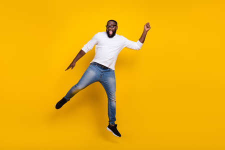 Full length photo of crazy handsome guy arm hold empty space umbrella isolated on yellow color backgroundの写真素材