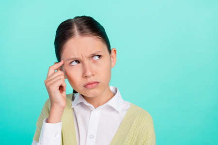 Photo of doubtful lady look empty space solve dilemma wear green top cardigan isolated teal color background.の写真素材