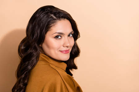 Profile side view portrait of attractive cheery wavy-haired woman copy blank space ad isolated over beige pastel color backgroundの写真素材