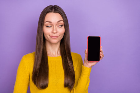 Photo of young girl wonder minded look cellphone connection 4g app isolated over purple color backgroundの写真素材