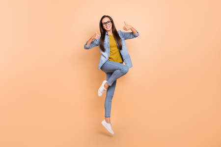 Full size photo of pretty female jumping show thumb-up recommending wear denim clothes isolated on...