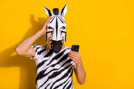 Photo of surprised guy in zebra mask read media news smart phone touch hand head isolated over...