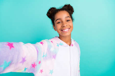 Photo of young attractive african lady good mood shoot selfie blogger sleepwear isolated over turquoise color backgroundの写真素材