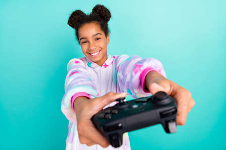 Photo of young excited afro entertainment weekend play video game isolated over turquoise color backgroundの写真素材